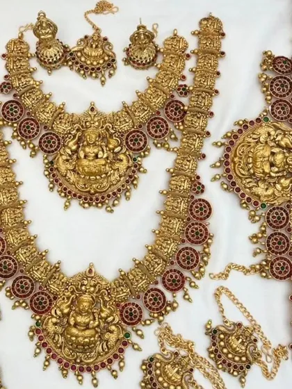 A complete South Indian temple jewellery bridal set in an antique gold finish, with intricate deity carvings.