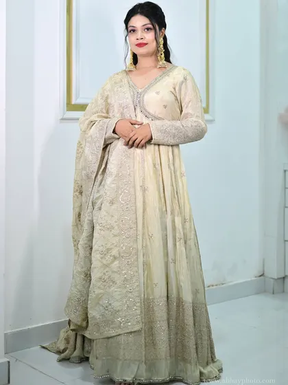 A full-length shot of the ivory anarkali gown, showing its flowing silhouette and the intricate embroidery along the hem.