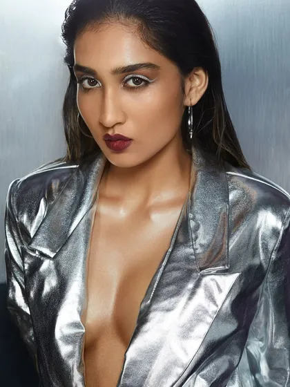 A cool and edgy look with a metallic silver jacket, wet-look hair, and a deep berry lip.