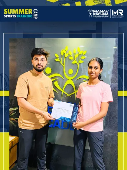 A coach presents a certificate to a participant at the closing ceremony of the summer camp. This moment marks the successful completion of an intensive and rewarding training program.