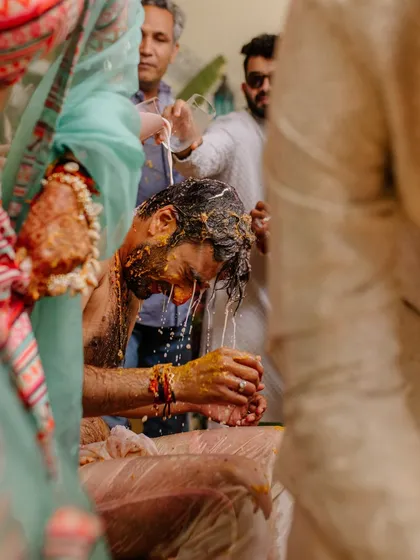 The playful moment of the groom getting drenched during the Haldi ceremony. I ensure the setup is perfect for capturing these fun, candid memories.