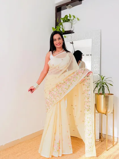 This cream-colored organza saree with delicate, pastel embroidery is the definition of grace. It's a very sophisticated and understated piece.