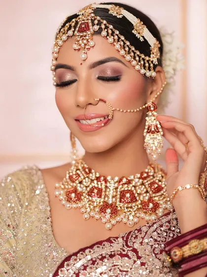 A beautiful shot of the bride looking down, showcasing the intricate mathapatti and earrings from the rental set.