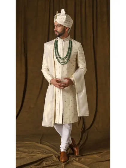Another angle of the pearl ivory sherwani, highlighting the intricate craftsmanship and the elegant fall of the fabric. This is timeless beauty, redefined for the modern groom.