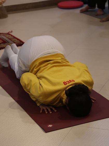 A student practices the eight limbed pose, a key transition that builds arm and core strength.