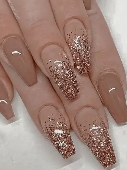 A classic and elegant glitter ombre. This design features a beautiful rose gold glitter fading into a warm nude base on long, coffin-shaped nails.