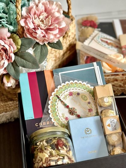 A thoughtful Rakhi hamper for your brother, including Carra chocolate, a jar of premium mixed dry fruits, a Man Company perfume, and a notebook.