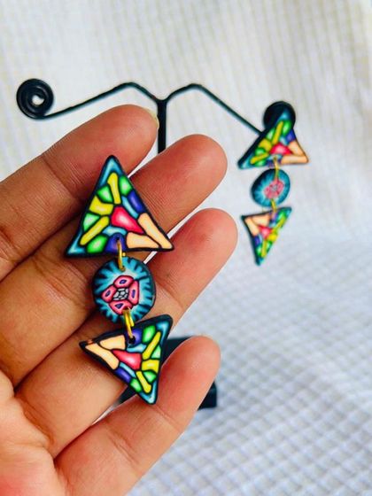 I love playing with geometric shapes. These triangular polymer clay earrings have a stained-glass effect and are assembled to create a playful, dangling look.