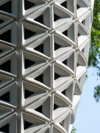 A tight shot on the geometric perforations of the tower, which are optimized for airflow.