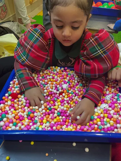 A sensory bin filled with colorful beads provides a wonderful tactile experience during our Christmas workshop. It's a fun and calming way to explore.