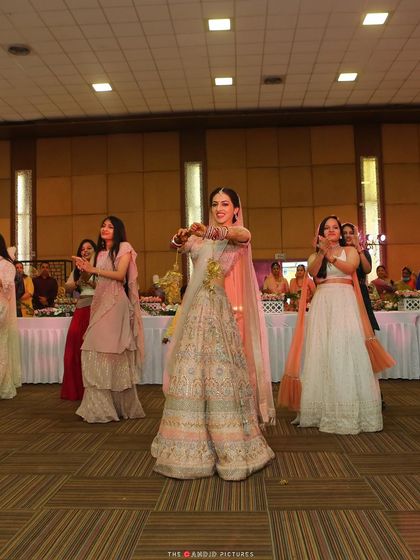 The bride leading her squad in a graceful dance move. This photo showcases the elegance and unity of a well-choreographed bridesmaids' performance.