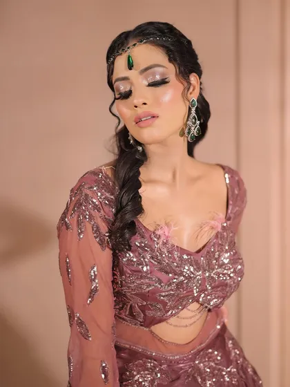 A close-up of the eye makeup for this glamorous look. The silver glitter on the lid adds a touch of sparkle, while the braided hairstyle adds a bohemian touch.