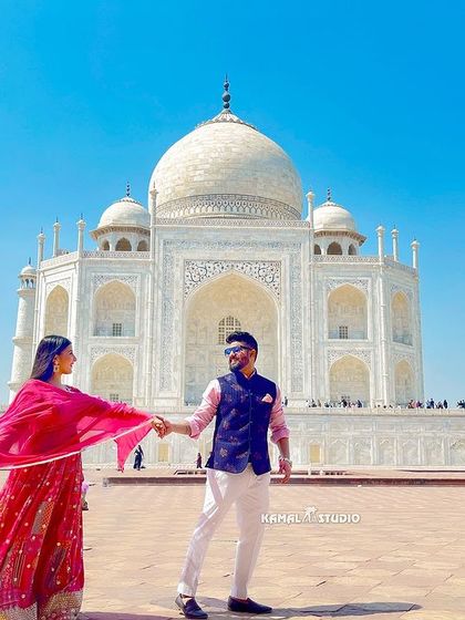 Leading the way to a new life together, with the Taj Mahal as your witness. The vibrant colors of the attire pop against the pristine white marble, creating a visually stunning photograph.