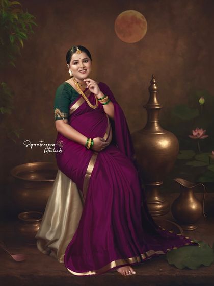 The rich colors and traditional props in this seated portrait evoke a sense of classic Indian art.