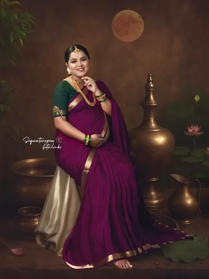 The rich colors and traditional props in this seated portrait evoke a sense of classic Indian art.