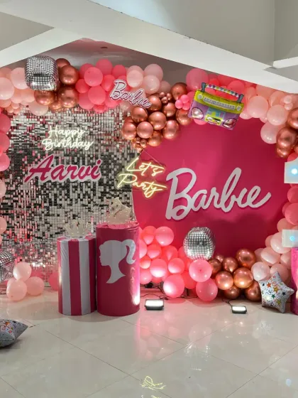 A closer look at our trendy Barbie theme, showing the "Let's Party Barbie" sign, marquee number, and the mix of pink and rose gold chrome balloons.