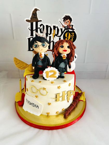 An adorable Harry Potter cake with cute, handcrafted figures of Harry and Hermione.
