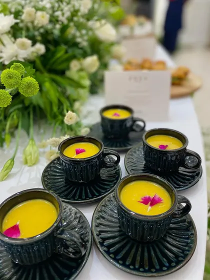 Another shot of the beautifully presented soup, garnished with an edible flower. It's these small, artistic touches that elevate our catering.