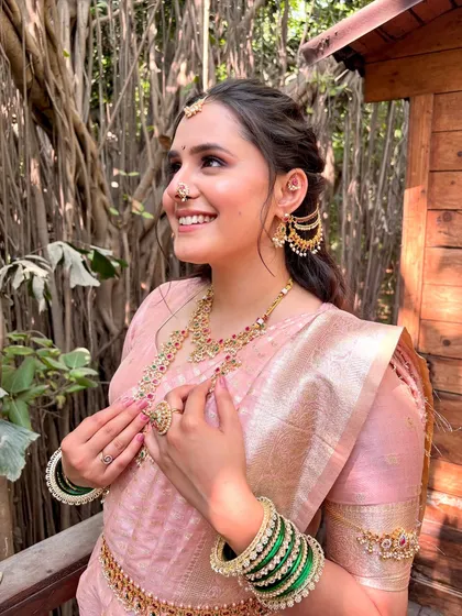 This is the radiant smile I love to see. For this beautiful Maharashtrian bride, we chose a soft, rosy makeup look to complement her pink Paithani saree. The focus was on creating a luminous, skin-like base that glowed in the natural light, making her feel absolutely unforgettable on her special day.