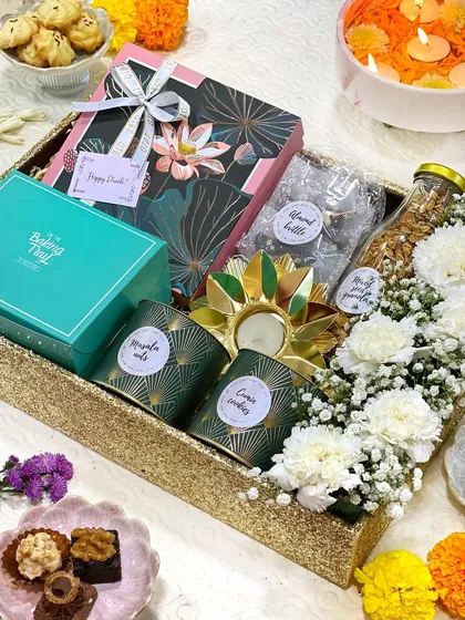 When it comes to festivals like Diwali, I love creating hampers that feel truly special. This one is a tray full of light and happiness, combining my handmade sweets and savories with fresh flowers and a beautiful decorative diya.