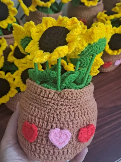 A close-up of one of my cheerful sunflower pots. The pot itself has a cute smiley face with little hearts, adding an extra layer of charm.