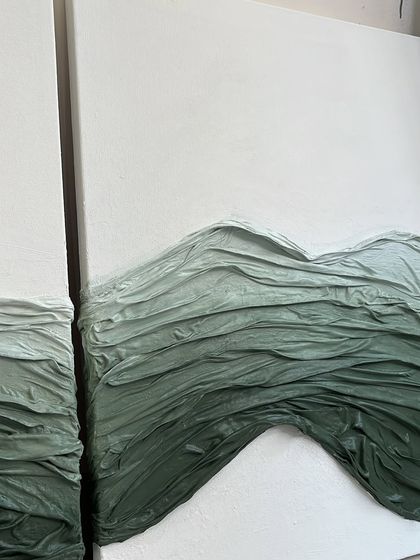 A diptych featuring waves of green fabric texture on a clean white canvas. This piece, commissioned for a Mumbai home, explores how different shades and textures can create a sense of movement and depth.