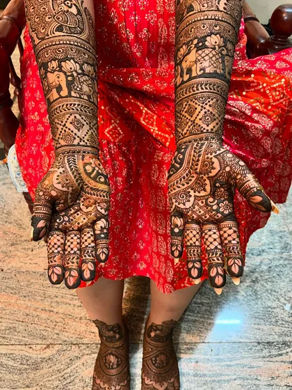 Full coverage bridal mehendi for hands and feet. The design is dense with traditional patterns, including elephants, lotuses, and intricate checkerboard fills.