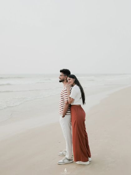 A quiet moment looking out at the ocean. These wider shots capture both the couple's connection and the beautiful coastal scenery.