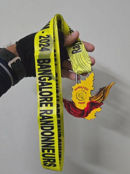 The reward for a tough day on the saddle. A finisher holds up the intricately designed medal for the Rajyotsava 200k, a beautiful memento from a memorable ride organized by Bangalore Randonneurs.