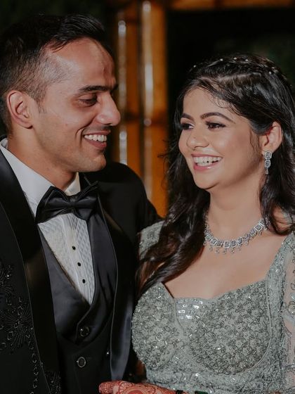 A happy moment between the newly engaged couple. The bride's makeup is soft and romantic, perfect for her silver-grey lehenga and diamond jewelry.