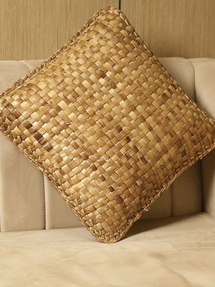 A square cushion cover woven from natural seagrass. This unique piece adds texture and an earthy, organic feel to a sofa or armchair, perfect for a coastal or bohemian-inspired interior.