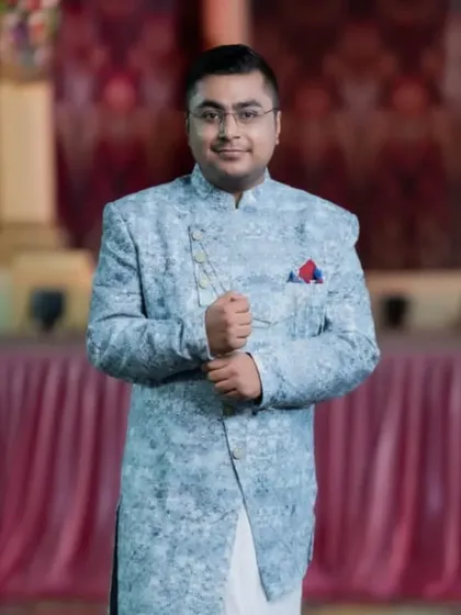 The groom looking dapper in his Indo-western attire. The styling is modern and sophisticated, suitable for an engagement or Sangeet.