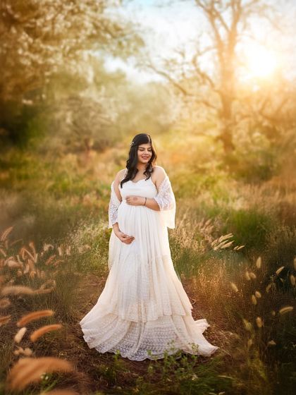 The full length view of the beautiful maternity gown in a dreamy, sun kissed field. This image showcases the styling and ethereal quality of my outdoor photoshoots.