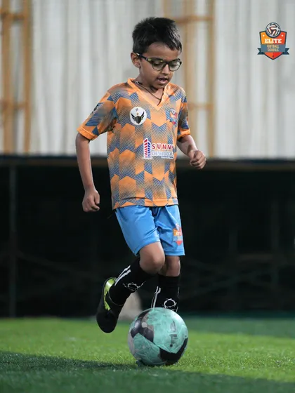 A player carefully dribbles the ball, focusing on keeping it close to his feet.