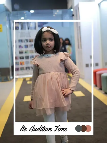 It's audition time. This young model is ready for her turn, practicing her pose in our audition space. This is the first step towards the main stage.
