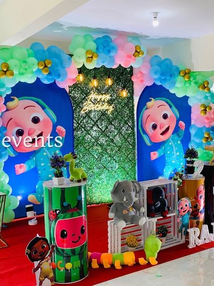 A full view of the Cocomelon theme with twin backdrops and a pastel balloon arch.