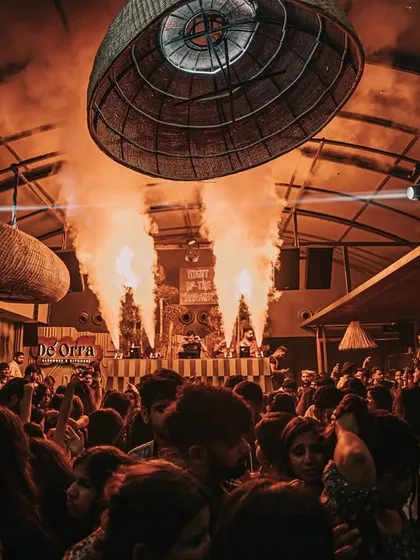 The view of the packed outdoor space at De'orra, with the stage lit up by fire effects.