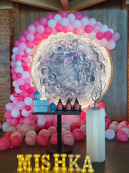 The full view of the moon-themed first birthday party for Mishka, showcasing the impressive backdrop and the floor covered in pink balloons.