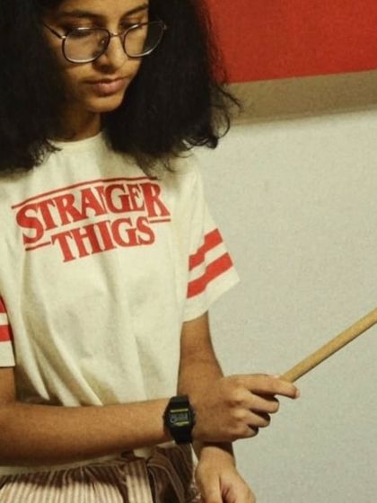 A focused shot of a student holding her drumsticks. The journey to becoming a great drummer starts with learning how to hold the sticks correctly.
