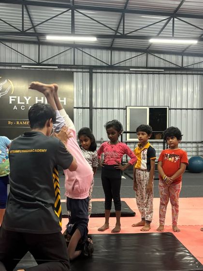 Hands-on correction is key. I help a young student find the right balance and alignment in her headstand.