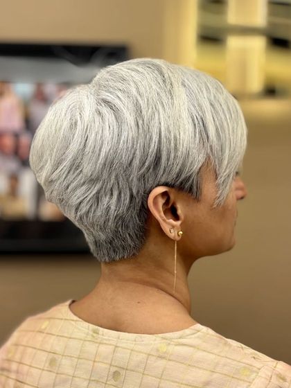 A beautifully executed short pixie cut on silver hair. This style is sharp, modern, and incredibly chic, proving that short hair has no age limit.