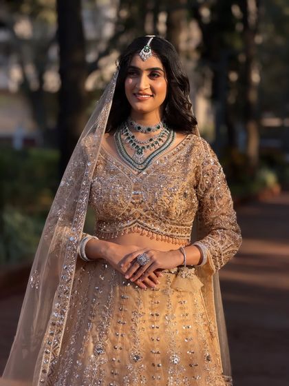 A full view of the bride in her stunning lehenga. The hairstyle is kept simple and elegant to balance the heavily embellished outfit.