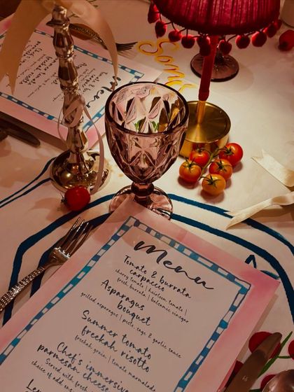 The charming, Italian-inspired place setting, complete with a custom menu, colored glassware, and a miniature table lamp, creating a cozy and intimate feel.
