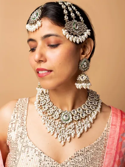 This shot displays a beautiful Kundan and pearl necklace set. The focus is on the intricate details and craftsmanship of the jewelry, making it ideal for an e-commerce listing.