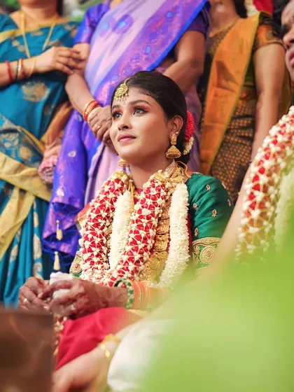 A candid shot of a bride during her wedding rituals. Her makeup remains flawless and radiant throughout the long ceremony.