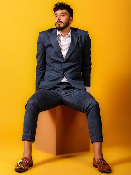 A relaxed yet assertive pose. The way he sits, combined with the bold yellow, creates a portrait that is both approachable and full of character.