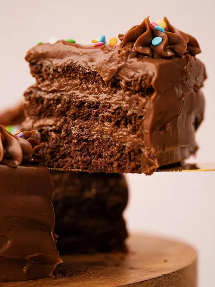 Here, I've lifted a slice of chocolate cake to showcase its moist, layered texture. This action makes the shot feel immediate and incredibly tempting, focusing entirely on the deliciousness of the cake itself.