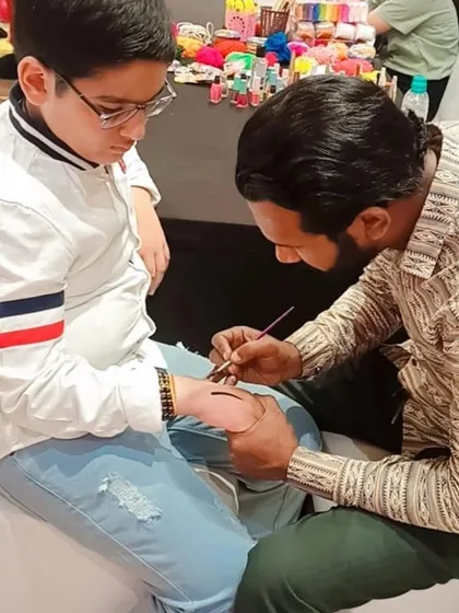 A young guest gets a temporary tattoo at a Barbie-themed party, showing how this activity can fit into any event theme.
