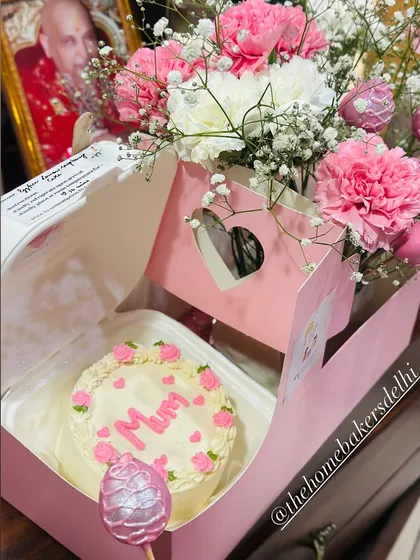 The perfect Mother's Day gift hamper. It features a custom 'Mum' bento cake in our signature pink box, paired with a beautiful bouquet of fresh carnations and glittery pink strawberry cake pops.