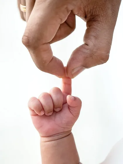 The smallest finger wrapped around yours. This macro shot captures the powerful connection and the delicate nature of your newborn.
